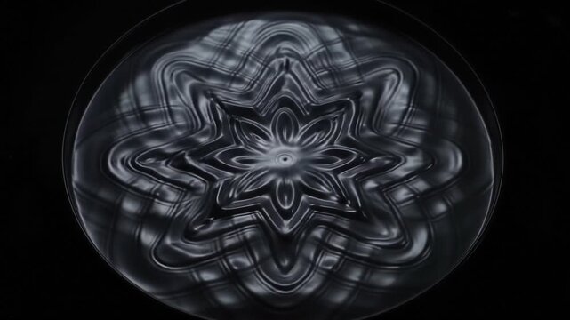 Top-down view of metallic liquid cymatic ripples in a black studio (for Dark Electronic & Melodic Progressive)
