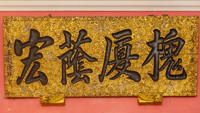 Black Chinese Calligraphy on a Gold Decorative Plaque