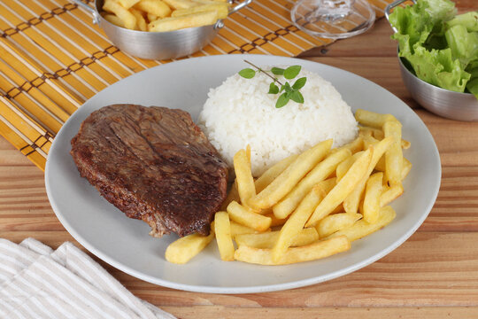 Prato com arroz, batata frita e carne