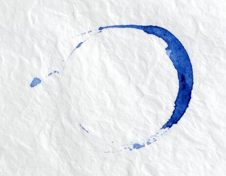 Indigo blue enso zen circle painted on textured washi paper