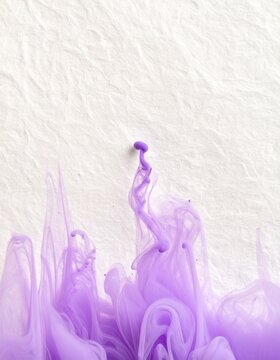 Purple ink rising in soft plumes through clear water