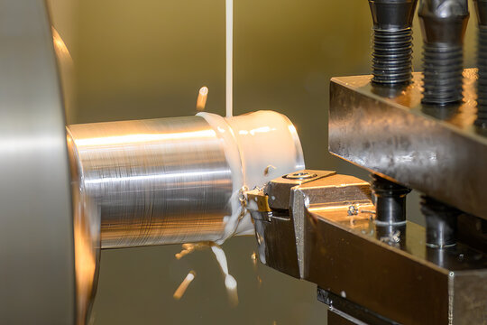 Close up of a metal shaft finish cutting process on a lathe machine using a liquid coolant method