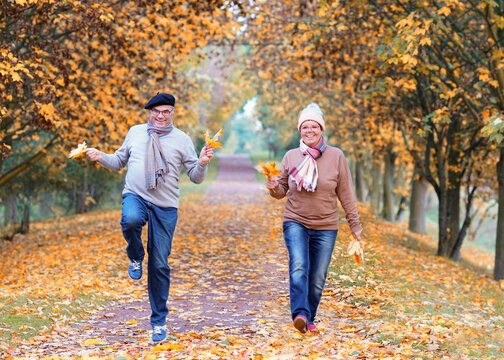 Joyful Couple Enjoying a Romantic Autumn Walk Surrounded by Colorful Leaves