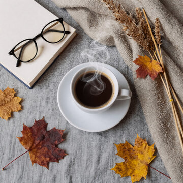 Hard Surface Linen Coffee. Autumnal Still Life: Cup Of Coffee, Books, Glasses On Grey Linen Bed With Beige Blanket And Reeds. Lifestyle Flat Lay Concept (Top View)