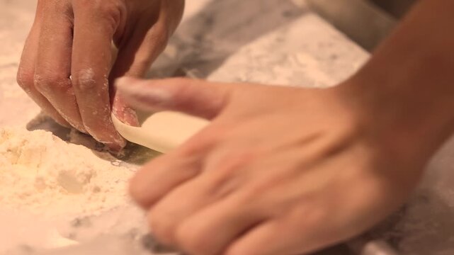Hand rolling dumpling dough with small wooden rolling pin for homemade food