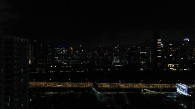 City skyline at night with illuminated skyscrapers and highway traffic lights in bangkok thailand urban nightscape panorama