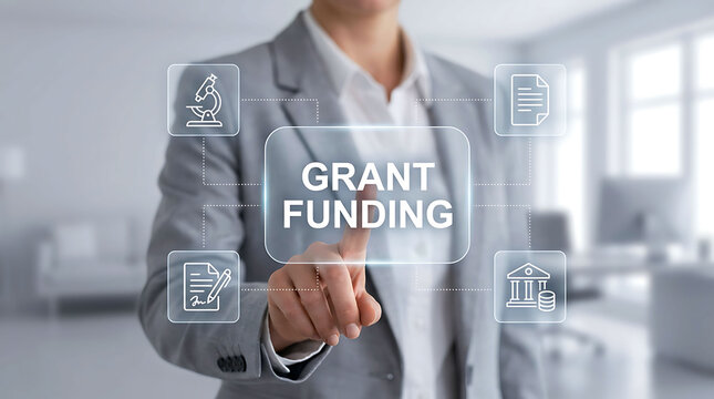 Professional woman in a suit pointing at a glowing grant funding concept screen