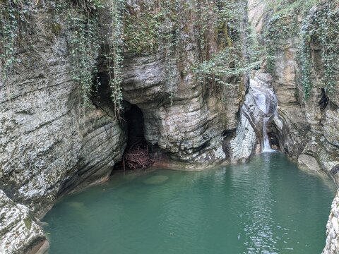 Hidden canyon with emerald green water pool limestone caves and small waterfall