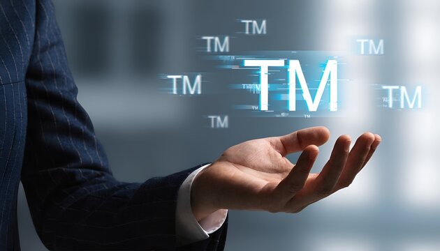 Business person holding a digital hologram of a trademark symbol in the air