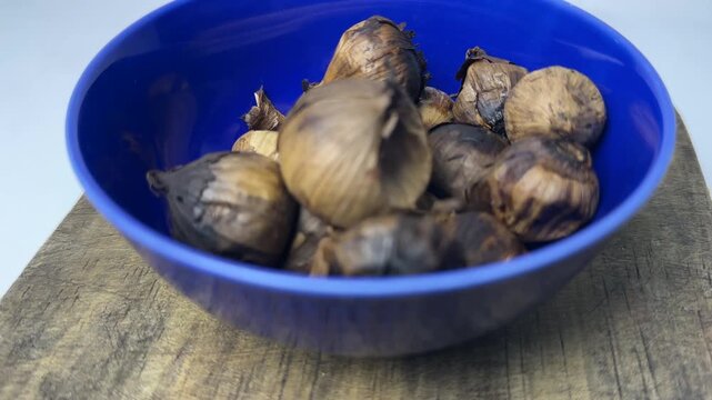 Single clove garlic for herbal health inside a blue bowl