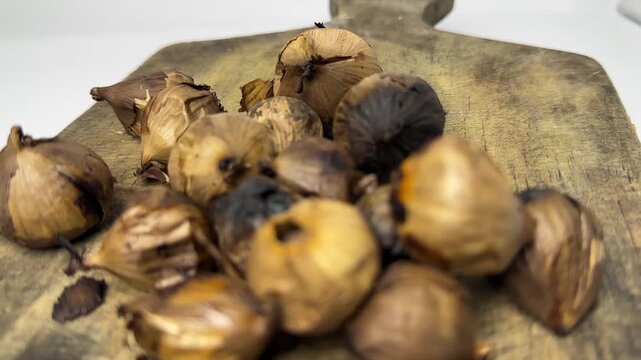 Single clove black garlic for herbal use on wooden board