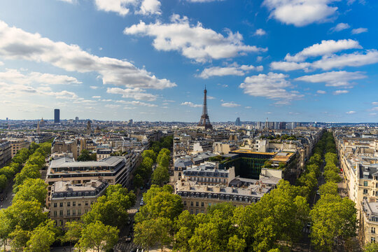 A wide, high-angle view captures the expansive Paris skyline and the iconic Eiffel Tower