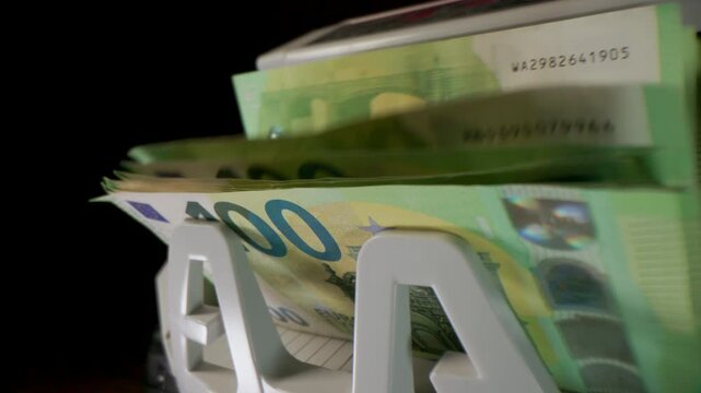 Extreme macro shot of 100 Euro banknotes in a rapid cash counting machine