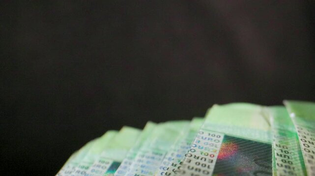 Extreme macro shot of the camera moving over 100 Euro banknotes