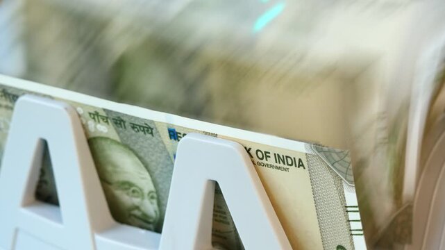 India, money. Economic success. Financial concept. Large quantity of Indian rupees being counted by a machine. Business background.

