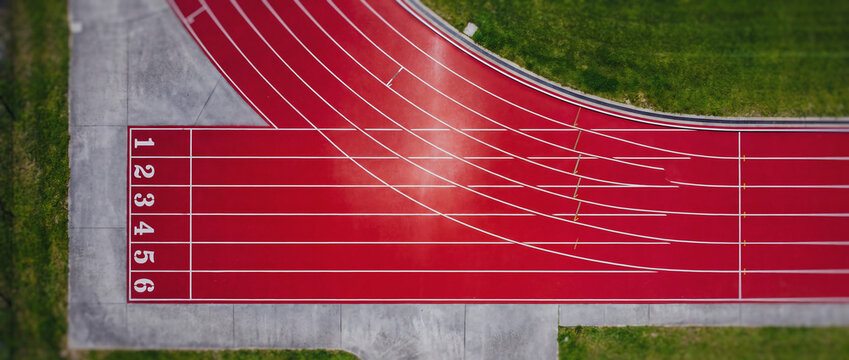 Red running track with numbered lanes in an outdoor sports stadium