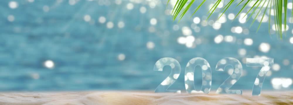 number 2027 year on sand beach with palm leaf and copy space, sunny nature background banner for travel season 2027, vacation, beach holidays