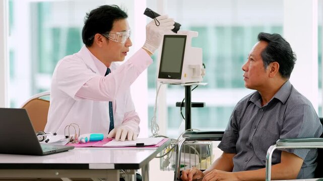 Medical examination of elderly Asian patient with doctor using diagnostic equipment during clinical consultation in modern clinic for professional healthcare support and assessment