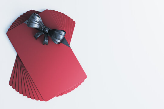 Red blank gift card stack with black ribbon bow, top view mockup, clean modern banking and discount concept with copyspace background. 3D Rendering