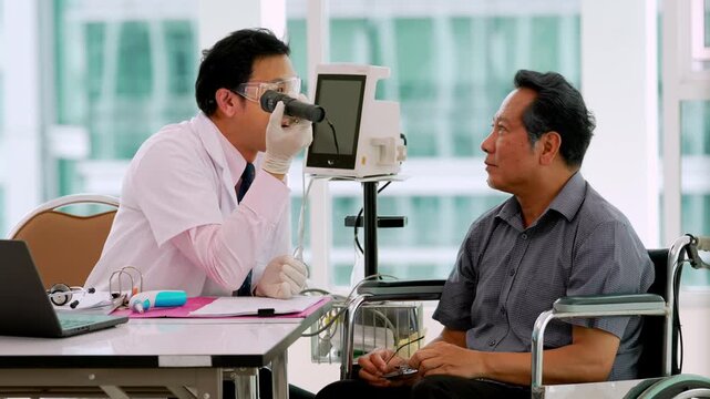 Medical elderly patient consultation with doctor during wheelchair examination healthcare clinic, discussing eye examination, diagnostic treatment, and accessible care through digital screen support