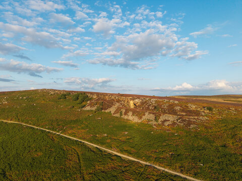Beautiful drone landscape image view over Burbage South Edge in Peak District during Summer heather sunset