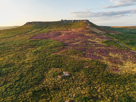 Beautiful drone landscape image view over Burbage South Edge in Peak District during Summer heather sunset
