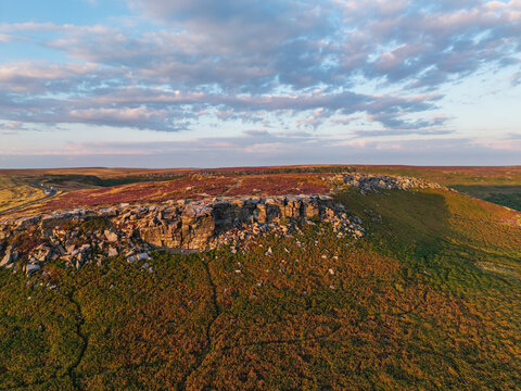 Beautiful drone landscape image view over Burbage South Edge in Peak District during Summer heather sunset