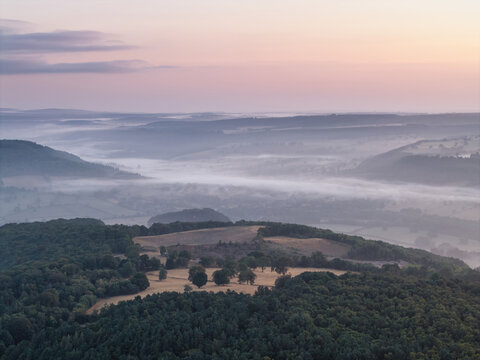 Beautiful drone landscape image over Stanton Moor in Summer Heather sunrise