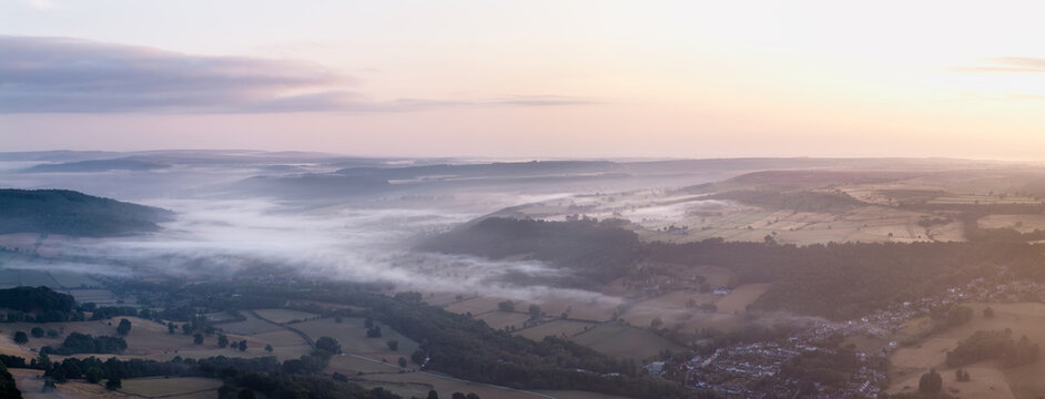 Beautiful drone landscape image over Stanton Moor in Summer Heather sunrise