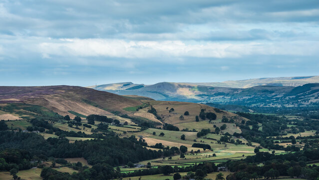 Stunning Peak District landscape from Surprise View with vibrant heather and dappled sunlight over the hills