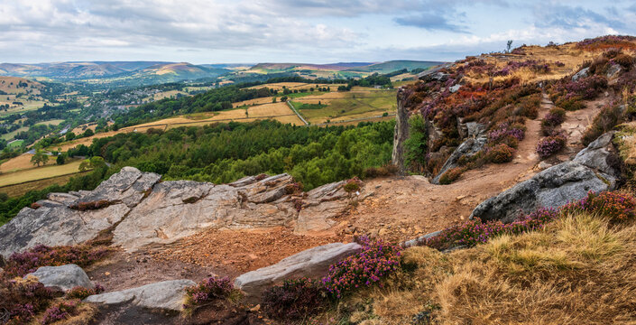 Stunning Peak District landscape from Surprise View with vibrant heather and dappled sunlight over the hills