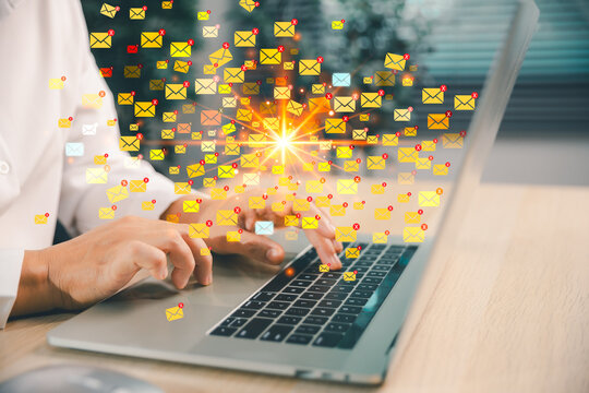 Business user works on a laptop surrounded by many email alerts, illustrating inbox overload, spam messages, digital distraction, bulk mailing, and excessive online communication traffic.