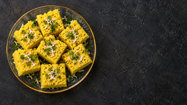 Gujarati Dhokla with Mustard Seeds and Coriander on Dark Background