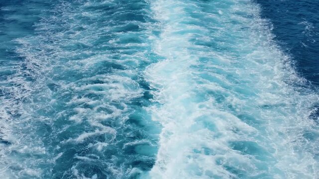 Close-up of the swirling wake left behind by a ferry traveling through the deep blue waters of the Aegean Sea, en route to Skopelos island in Greece