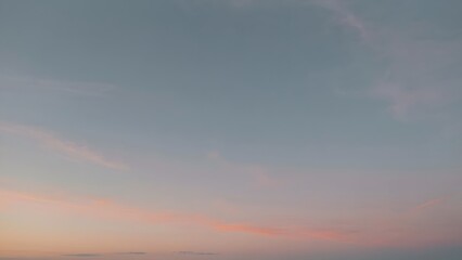 Obraz premium A serene sunset sky featuring soft pastel pink and blue gradient hues