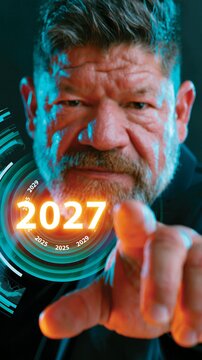 Man points at glowing digital year display. His intense gaze suggests focus or determination. Circular interface hints at futuristic technology. Suitable for tech, finance, or time-related concepts