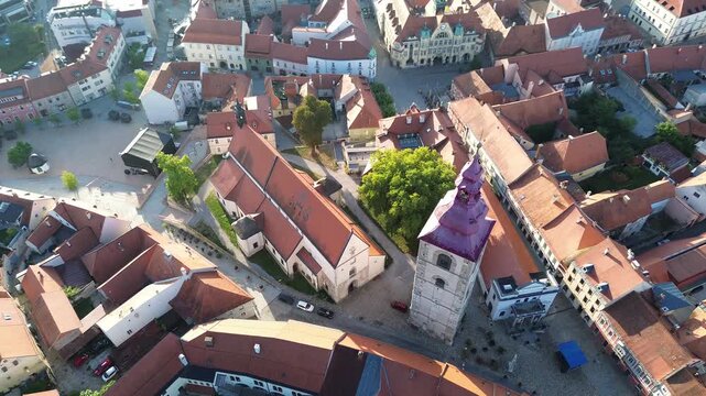 Aerial view of historic Ptuj in Slovenia, featuring St. George's Church, the city tower, red tiled rooftops, Slovenski trg and medieval streets.