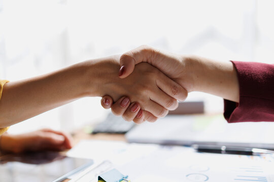 Business partners shaking hands, symbolizing successful collaboration and an important agreement being reached during a professional meeting in an office setting