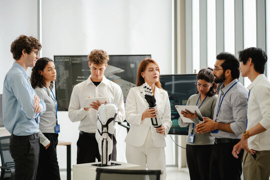Diverse technology professionals collaborating around a humanoid robot while discussing artificial intelligence, robotics, research, and innovation in a modern workplace.