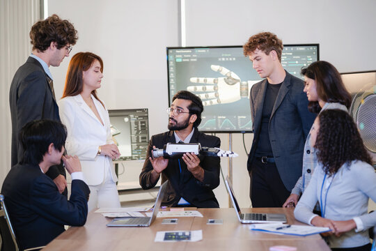 Diverse technology professionals collaborating around a humanoid robot prototype while discussing robotics, artificial intelligence, engineering, and innovation.