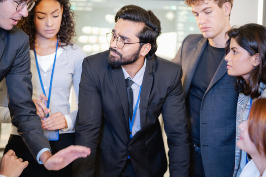 Diverse business professionals collaborating in a modern workplace, sharing ideas and discussing project strategy during a team meeting.