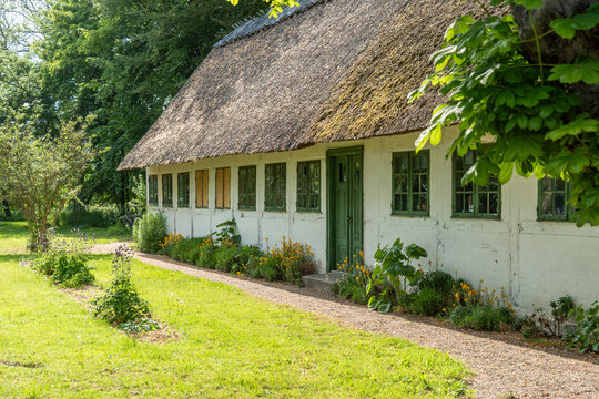 Traditionelles reetgedecktes Bauernhaus unter blauem Himmel auf der Insel Moen