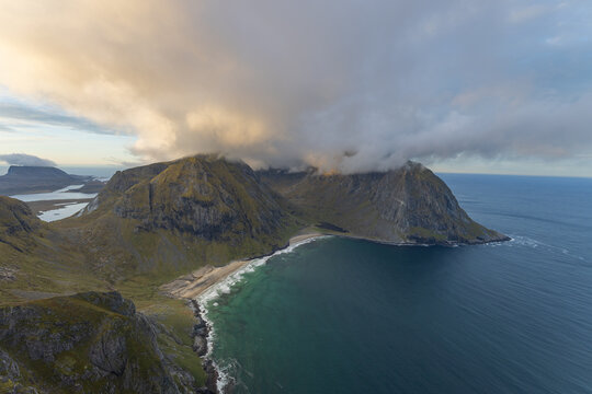 Adventurers enjoy panoramic views over the stunning Ryten Kvalvika Beach Trail in Lofoten, Norway.