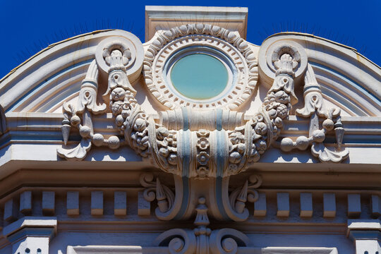 Ornate stucco pediment with round oculus window and fruit garlands, Cannes, French Riviera