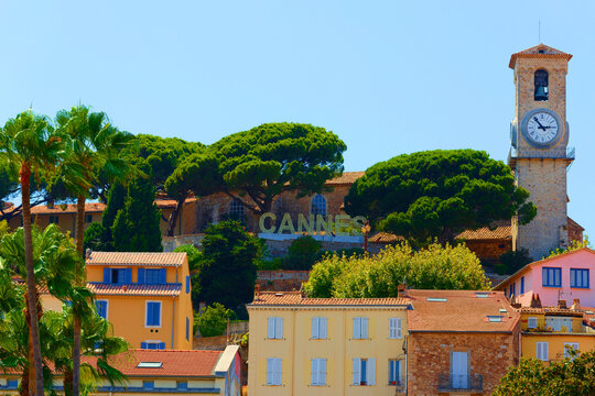 Old town of Cannes with stone clock tower, pine trees and colorful Provencal houses, French Riviera