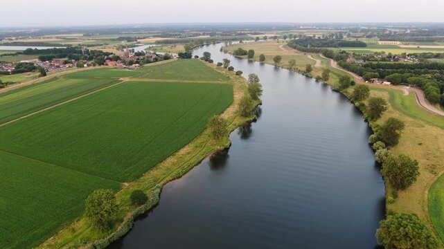 Drone flyover of a river bend and green fields near a Dutch drone shot