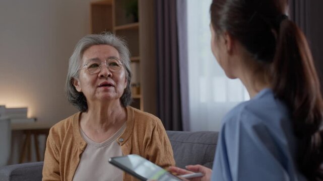 Senior Asian woman consulting female nurse about dizziness and headache symptoms