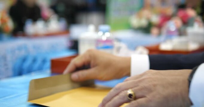 Close up of businessman hand opening brown envelope and taking out document in meeting