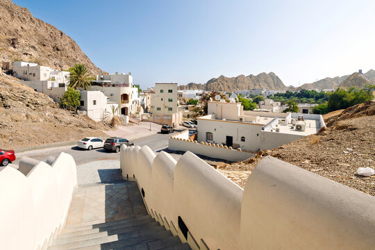 View from the stairs near the Muscat Gate Museum looking over the historic whitewashed residential district and Al Hajar Mountains in Old Muscat, Oman.