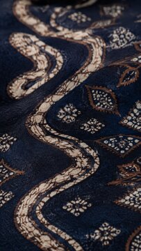 Traditional Indonesian Parang batik fabric pattern close up background, brown and cream textile design with intricate ethnic motifs and wax-resist dyeing details.